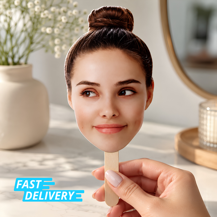 Hand holding a custom big head cutout face on a wooden stick with a Fast Delivery badge