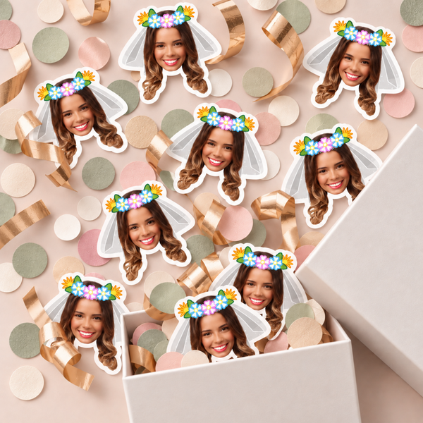 Custom bride face confetti with flower crown and veil scattered with rose gold ribbon beside a gift box